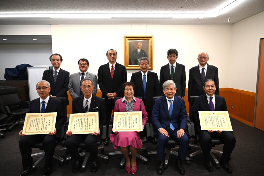 前列左から、髙栁幸雄理事／松苓会幹事長、七五三和男理事／附属柏中学・高等学校長、鈴木久子様、水戸英則理事長、飛田正太郎評議員／教学事務部長 後列左から、菅原義博理事／事務局長、西畑一哉常任理事、佐藤晋常任理事／学長、五十嵐清常任理事、鵜飼敦之理事／附属高等学校長、平野光治評議員／松苓会会長